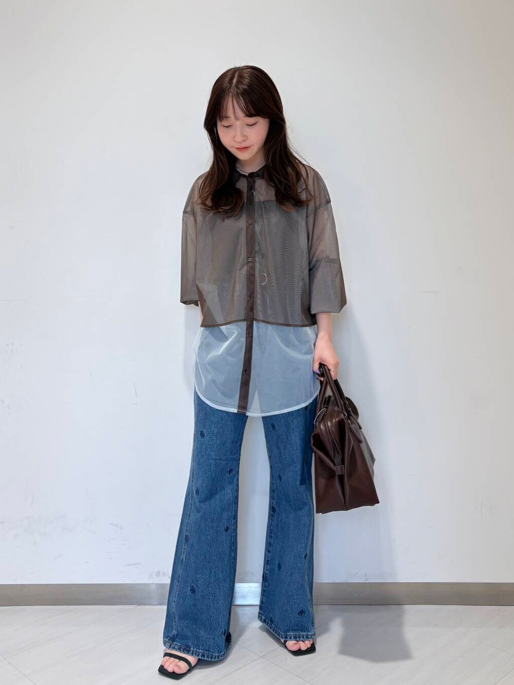 ブルー系のサンダル、ブラック系のキャミソール、ブラウン系のボストンバッグを着用したレディースの夏コーディネートの2枚目の写真