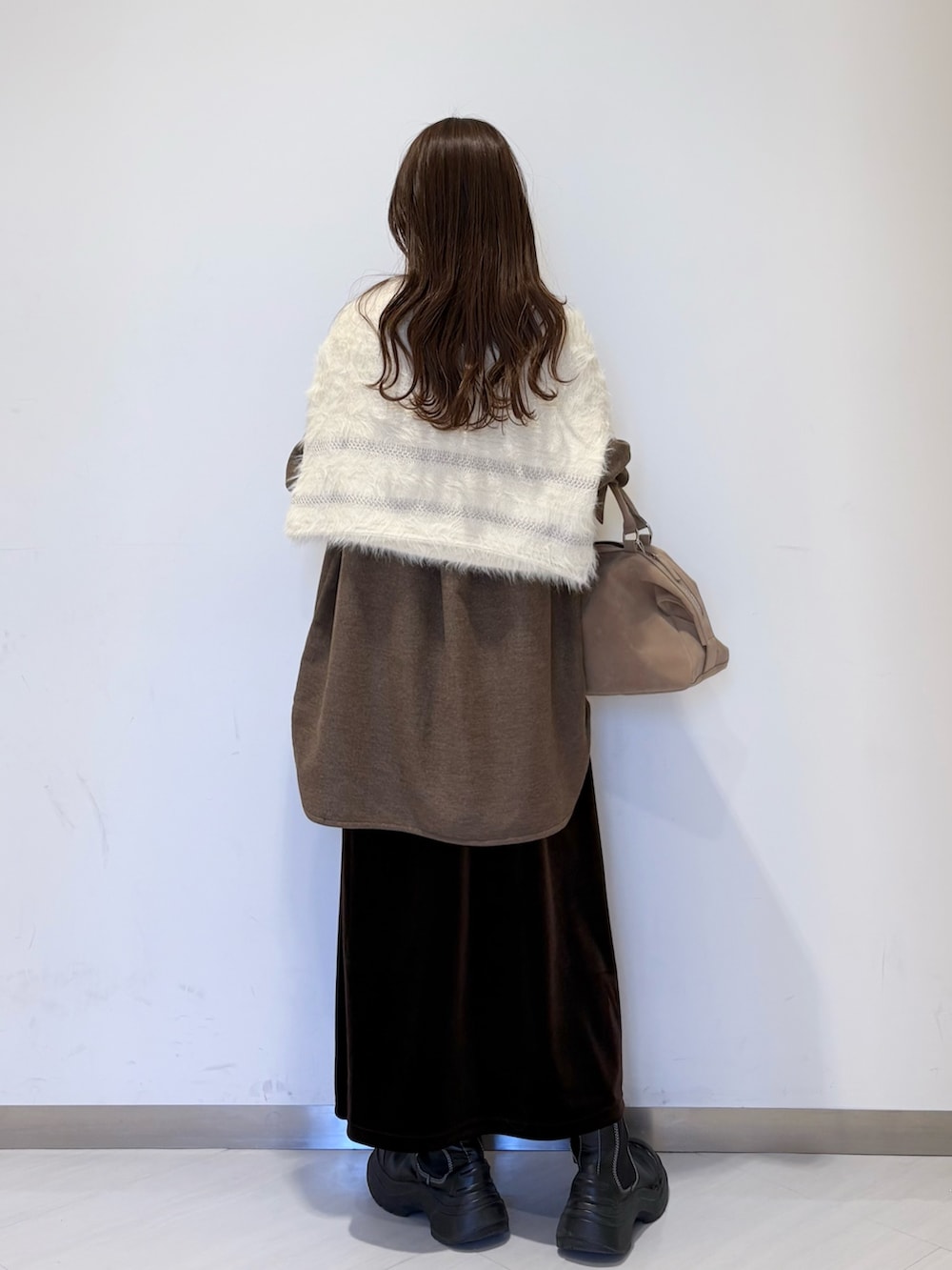 ブラウン系のシャツ/ブラウス、ホワイト系のニット/セーター、ブラウン系のスカートを着用したレディースの冬コーディネートの2枚目の写真