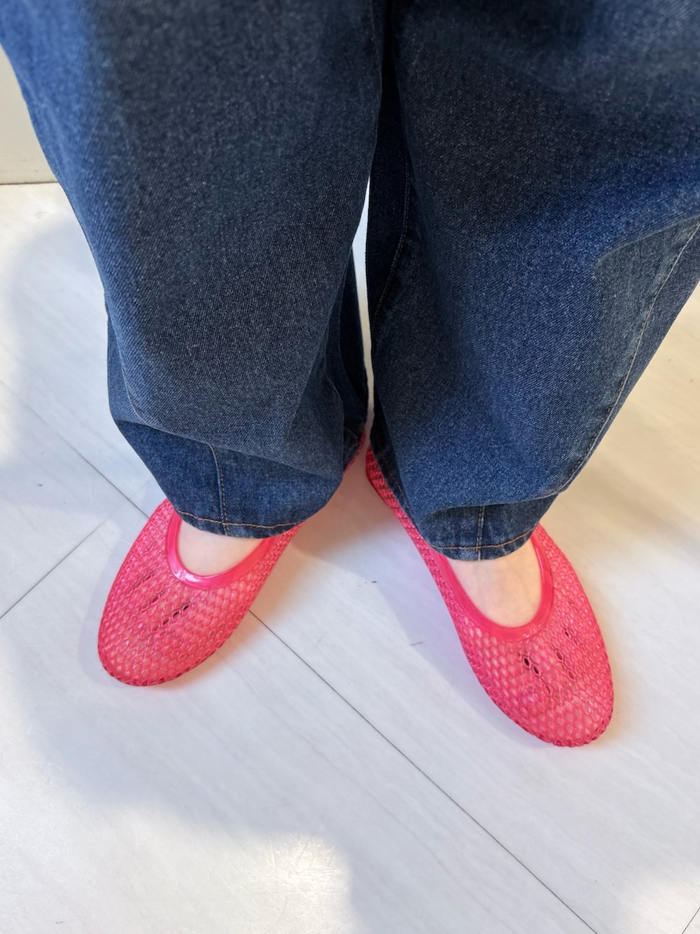 グレー系のニット/セーター、ブルー系のデニムパンツ、ブラック系のトートバッグを着用したレディースの春コーディネートの6枚目の写真