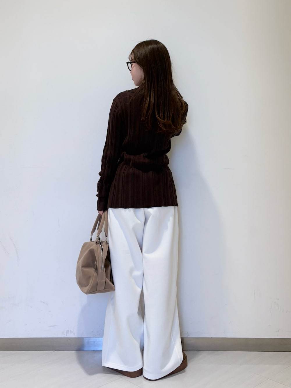 ブラウン系のニット/セーター、ホワイト系のその他パンツ、ベージュ系のボストンバッグを着用したレディースの冬コーディネートの2枚目の写真