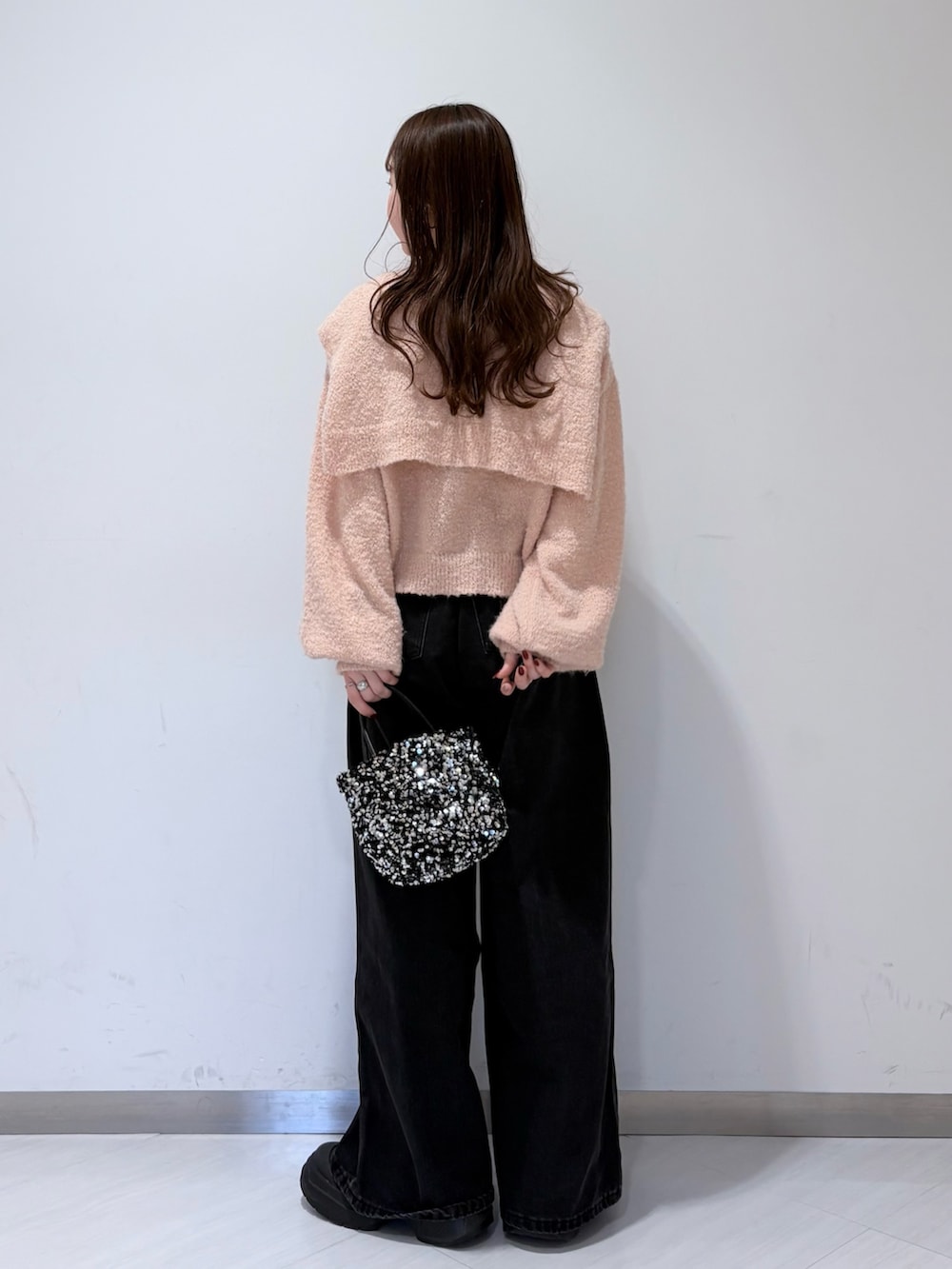 ピンク系のニット/セーター、ブラック系のデニムパンツを着用したレディースの冬コーディネートの3枚目の写真