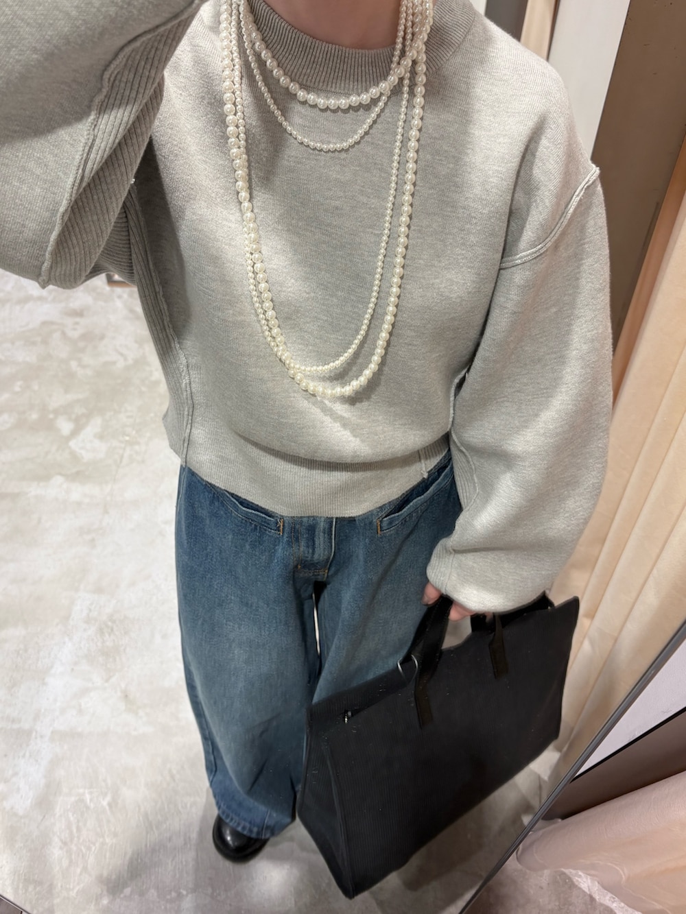 グレー系のニット/セーター、ブルー系のデニムパンツ、ブラック系のその他シューズを着用したレディースの秋コーディネートの4枚目の写真