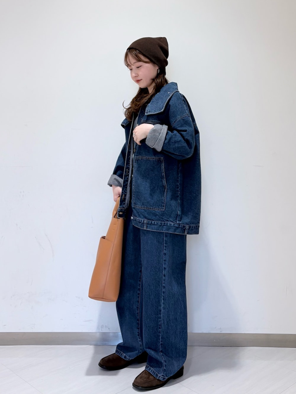 ブルー系のブルゾン、ブラウン系のローファー、イエロー系のショルダーバッグを着用したレディースの冬コーディネートの2枚目の写真