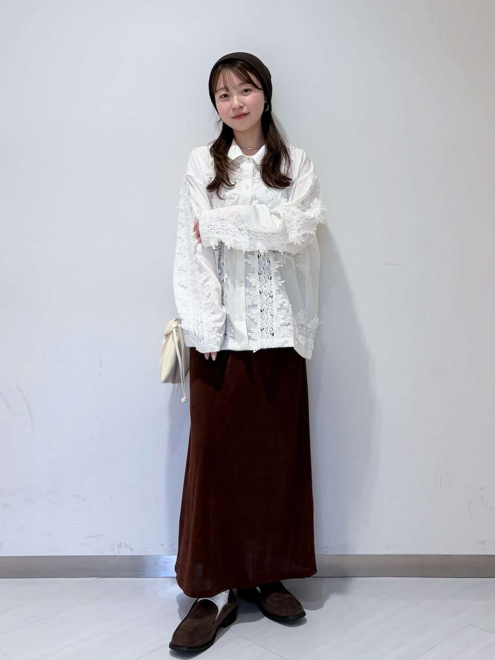 ホワイト系のシャツ/ブラウス、ブラウン系のスカート、ブラウン系のローファーを着用したレディースの冬コーディネートの2枚目の写真