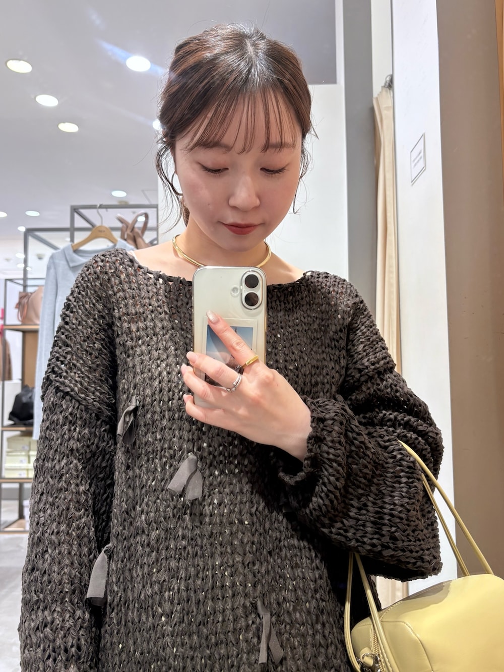 ベージュ系のスカート、ブラウン系のニット/セーター、ベージュ系のショルダーバッグを着用したレディースの冬コーディネートの5枚目の写真