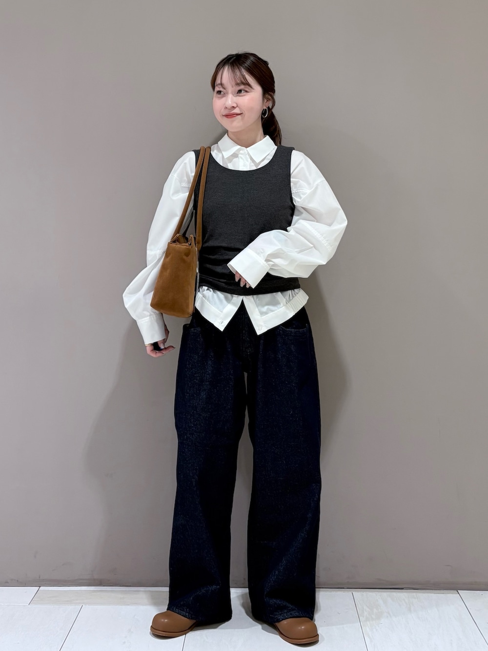 ホワイト系のシャツ/ブラウス、ブラウン系のブーツ、ブルー系のデニムパンツを着用したレディースの冬コーディネートの2枚目の写真