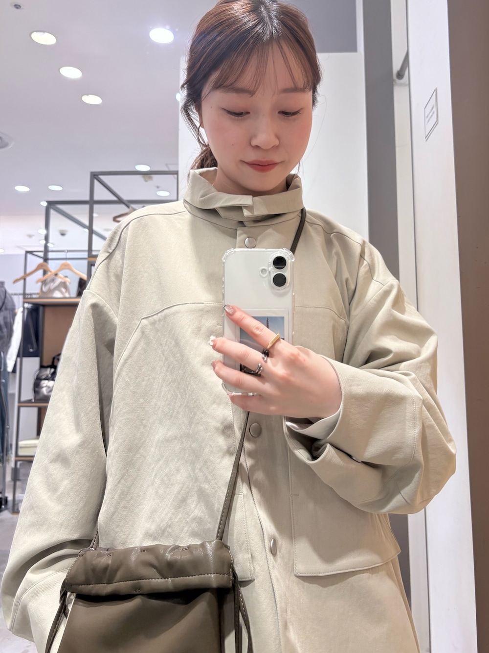 グリーン系のショルダーバッグ、ベージュ系のその他アウター、ホワイト系のワンピースを着用したレディースの春コーディネートの7枚目の写真