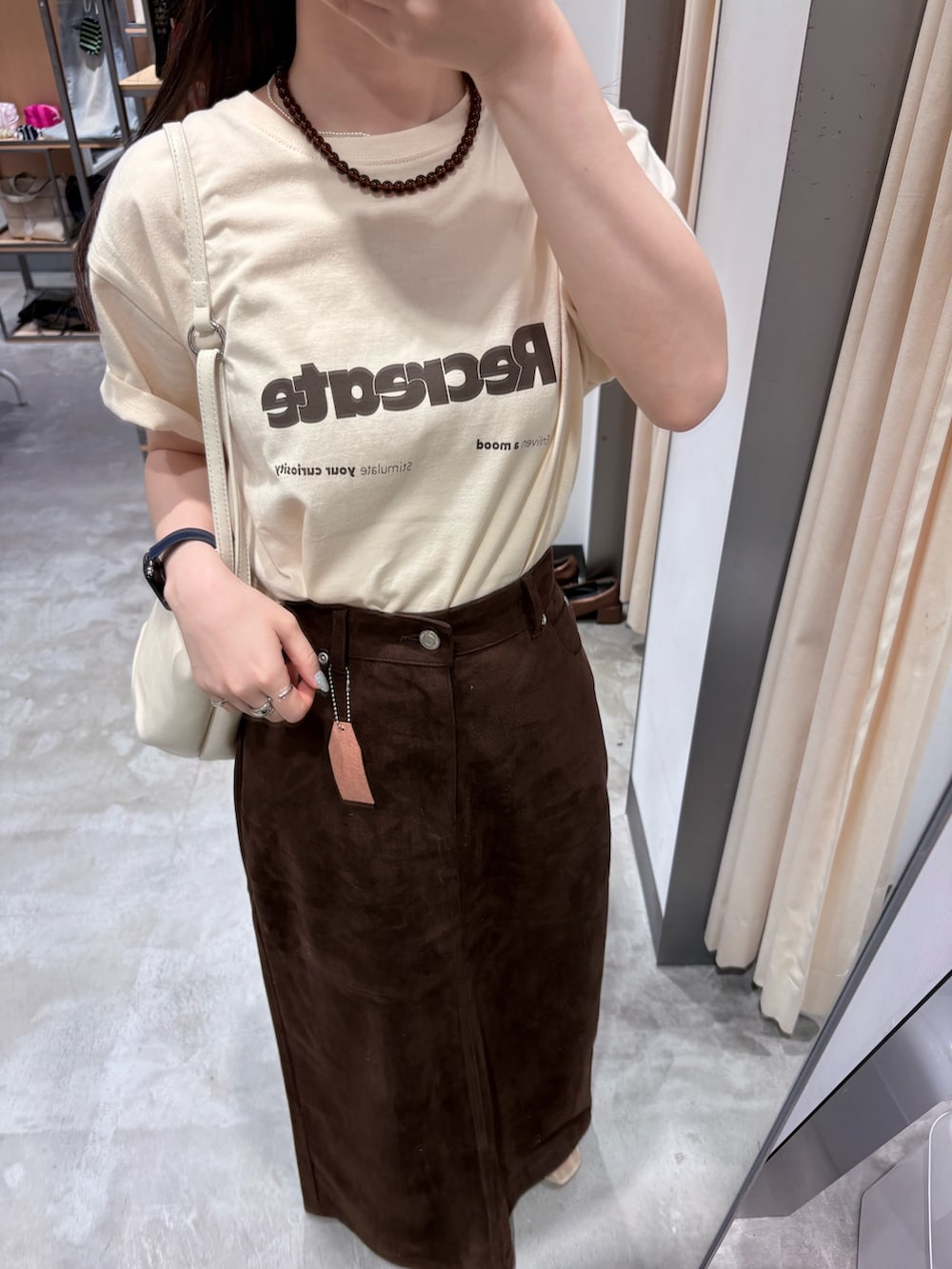 ブラウン系のスカート、ホワイト系のショルダーバッグ、ホワイト系のTシャツ/カットソーを着用したレディースの夏コーディネートの5枚目の写真
