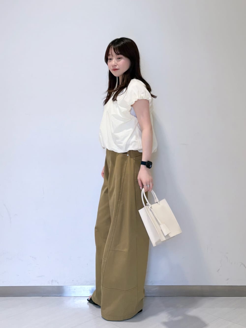 ホワイト系のシャツ/ブラウス、グリーン系のその他パンツ、ホワイト系のハンドバッグを着用したレディースの春コーディネートの2枚目の写真