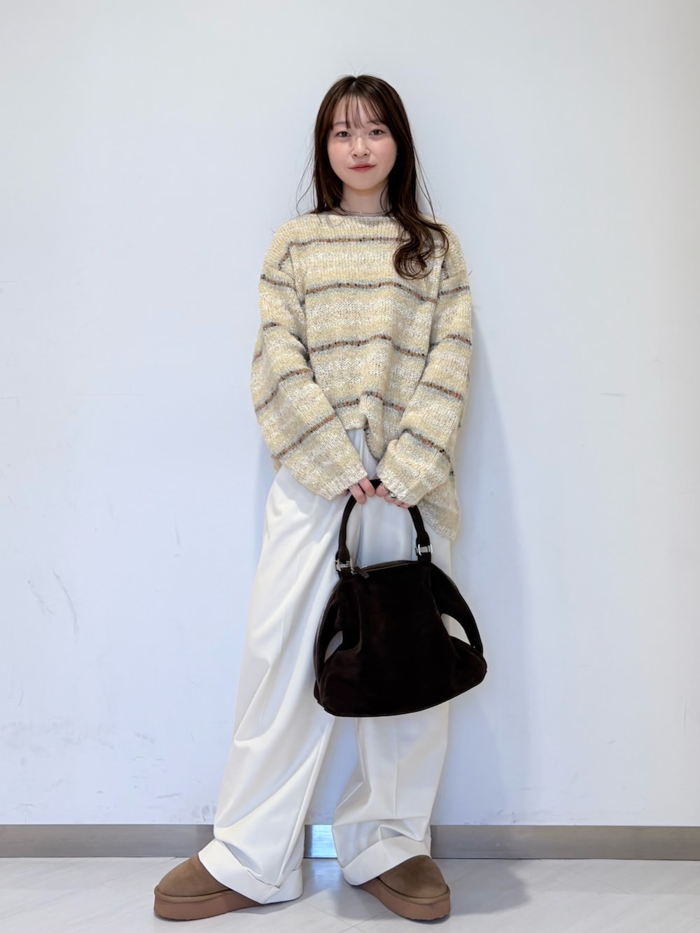 ブラウン系のその他アウター、ホワイト系のニット/セーター、ブラウン系のボストンバッグを着用したレディースの冬コーディネートの4枚目の写真