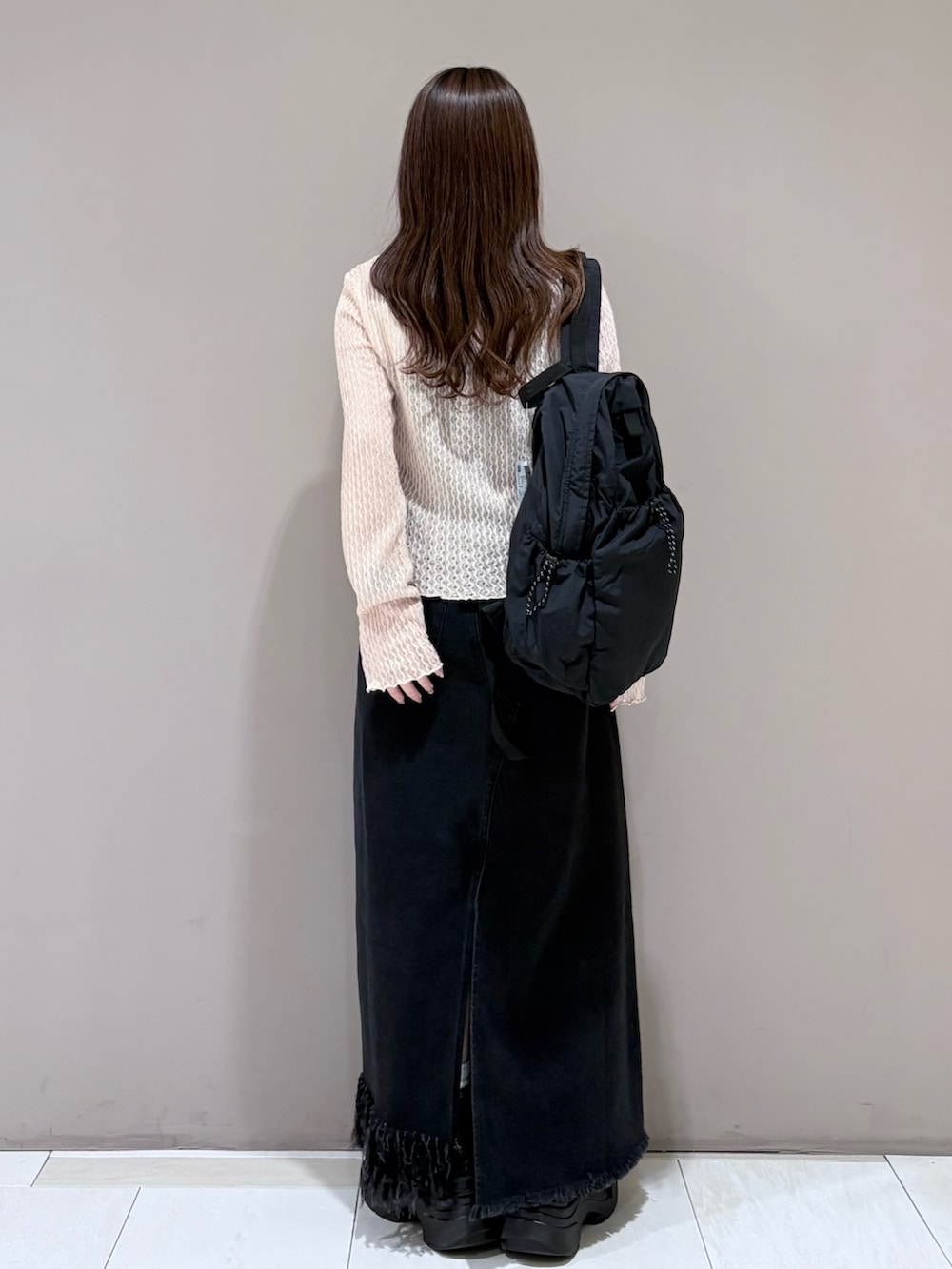 ピンク系のTシャツ/カットソー、ブラック系のスカート、ブラック系のバックパック/リュックを着用したレディースの春コーディネートの3枚目の写真