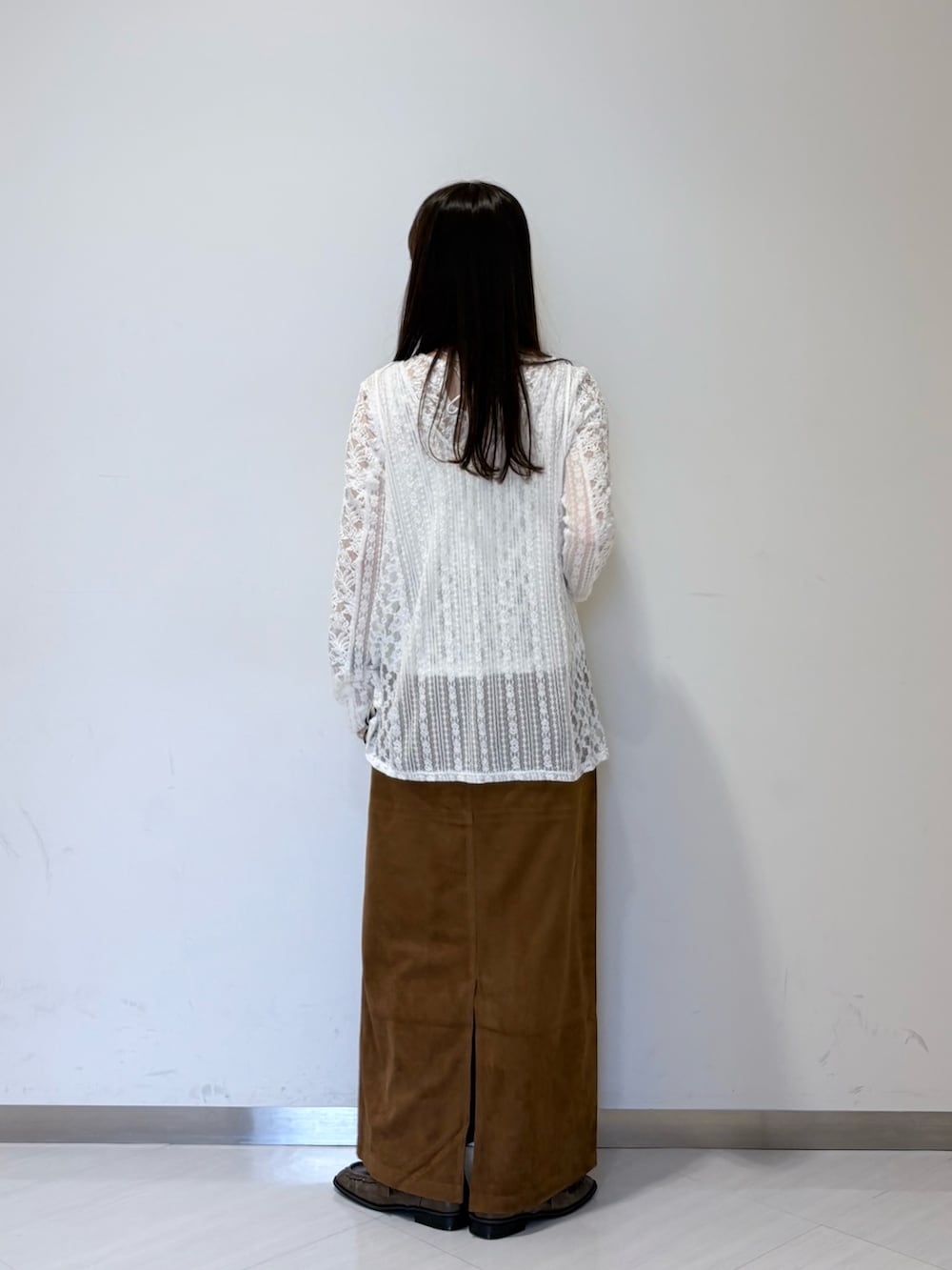 ホワイト系のカーディガン/ボレロ、ブラウン系のスカート、ブラウン系のローファーを着用したレディースの夏コーディネートの3枚目の写真