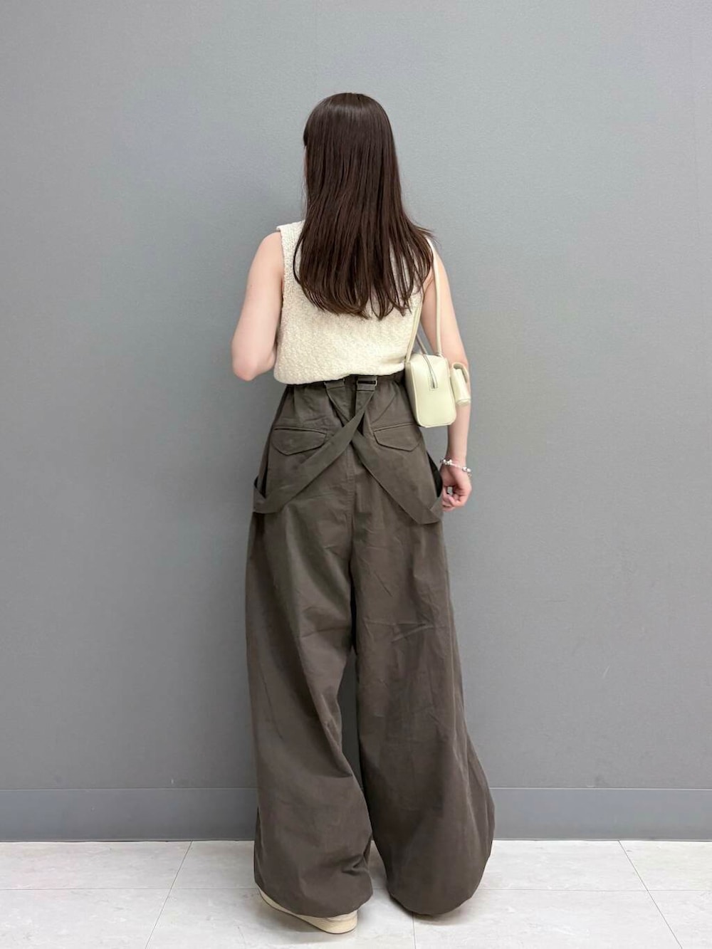 ホワイト系のショルダーバッグ、ホワイト系のニット/セーター、ブラウン系のその他パンツを着用したレディースの夏コーディネートの3枚目の写真