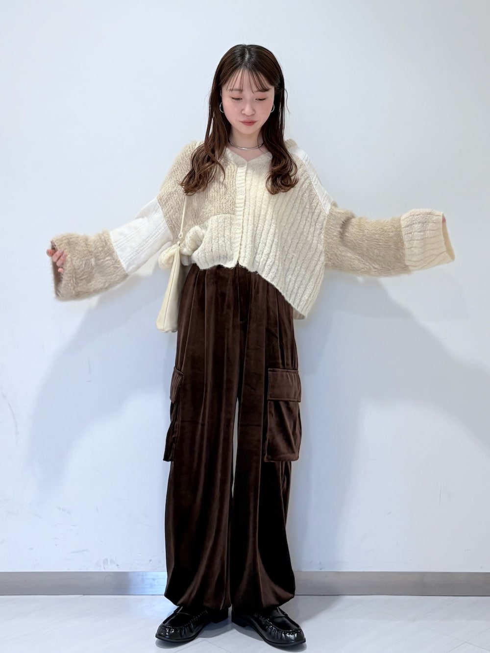 ホワイト系のカーディガン/ボレロ、ブラウン系のその他パンツ、ブラック系のその他シューズを着用したレディースの秋コーディネートの2枚目の写真