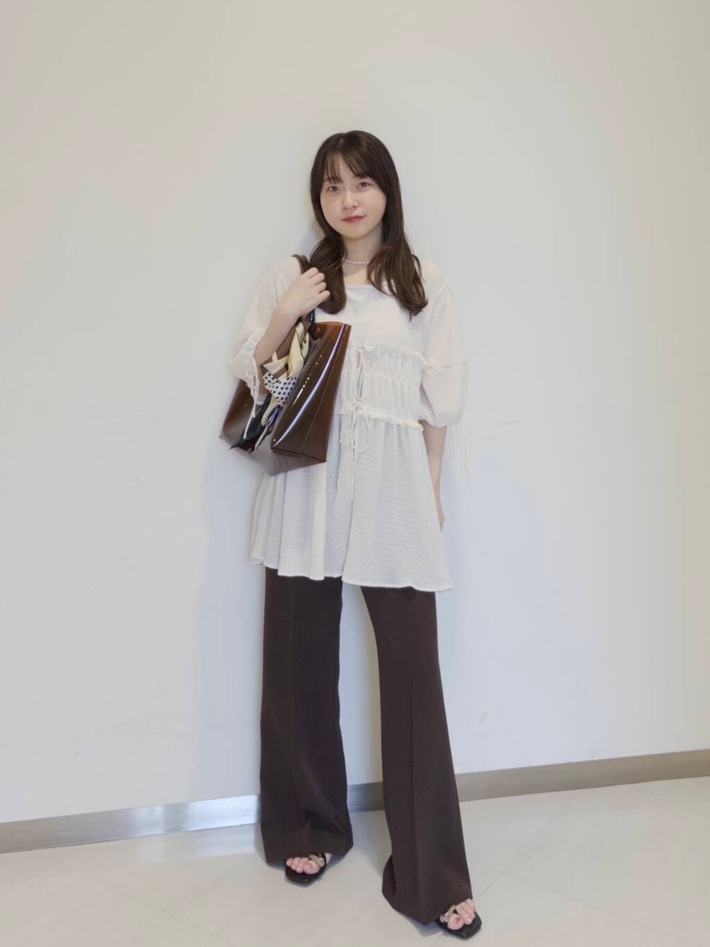 ブラウン系のトートバッグ、ブラウン系のサンダル、ブラウン系のその他パンツを着用したレディースの夏コーディネートの2枚目の写真