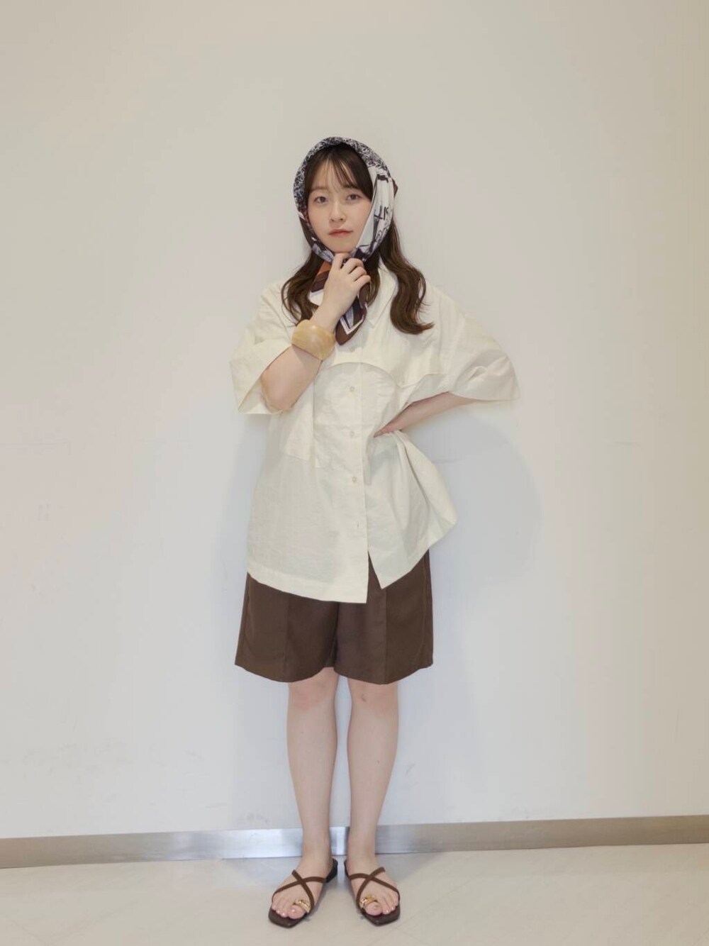 ブラウン系のその他パンツ、ブラウン系のサンダル、ホワイト系のキャミソールを着用したレディースの夏コーディネートの2枚目の写真