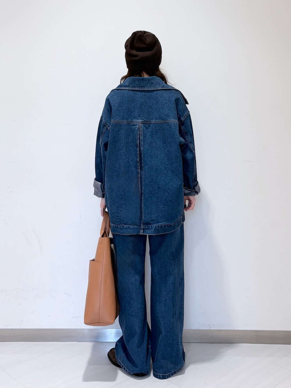 ブルー系のブルゾン、ブラウン系のローファー、イエロー系のショルダーバッグを着用したレディースの冬コーディネートの4枚目の写真