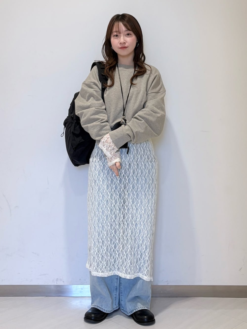 ベージュ系のスウェット、ブラック系のショルダーバッグ、ブルー系のデニムパンツを着用したレディースの春コーディネートの4枚目の写真