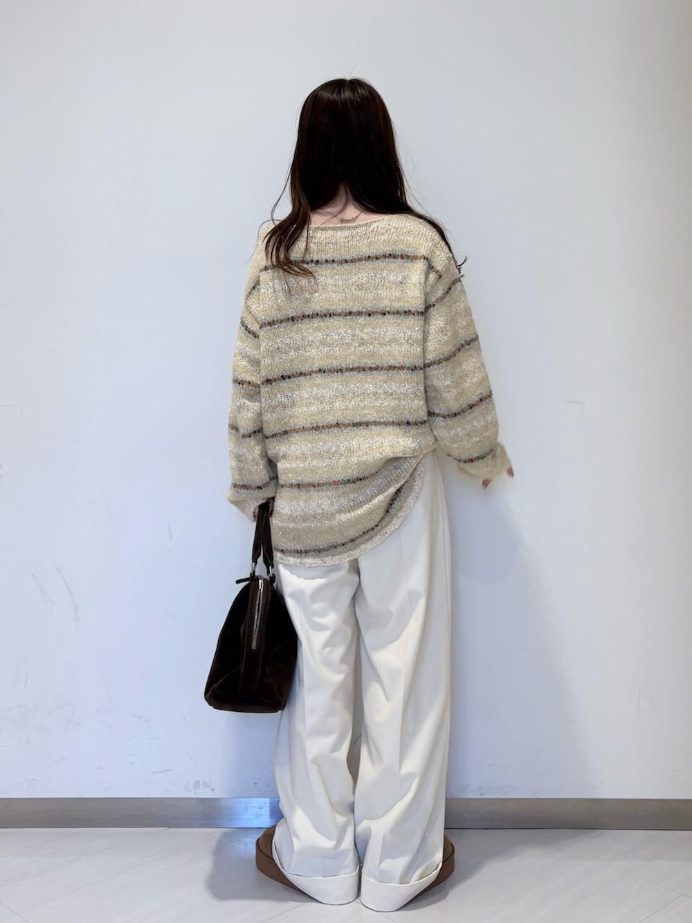 ブラウン系のその他アウター、ホワイト系のニット/セーター、ブラウン系のボストンバッグを着用したレディースの冬コーディネートの5枚目の写真