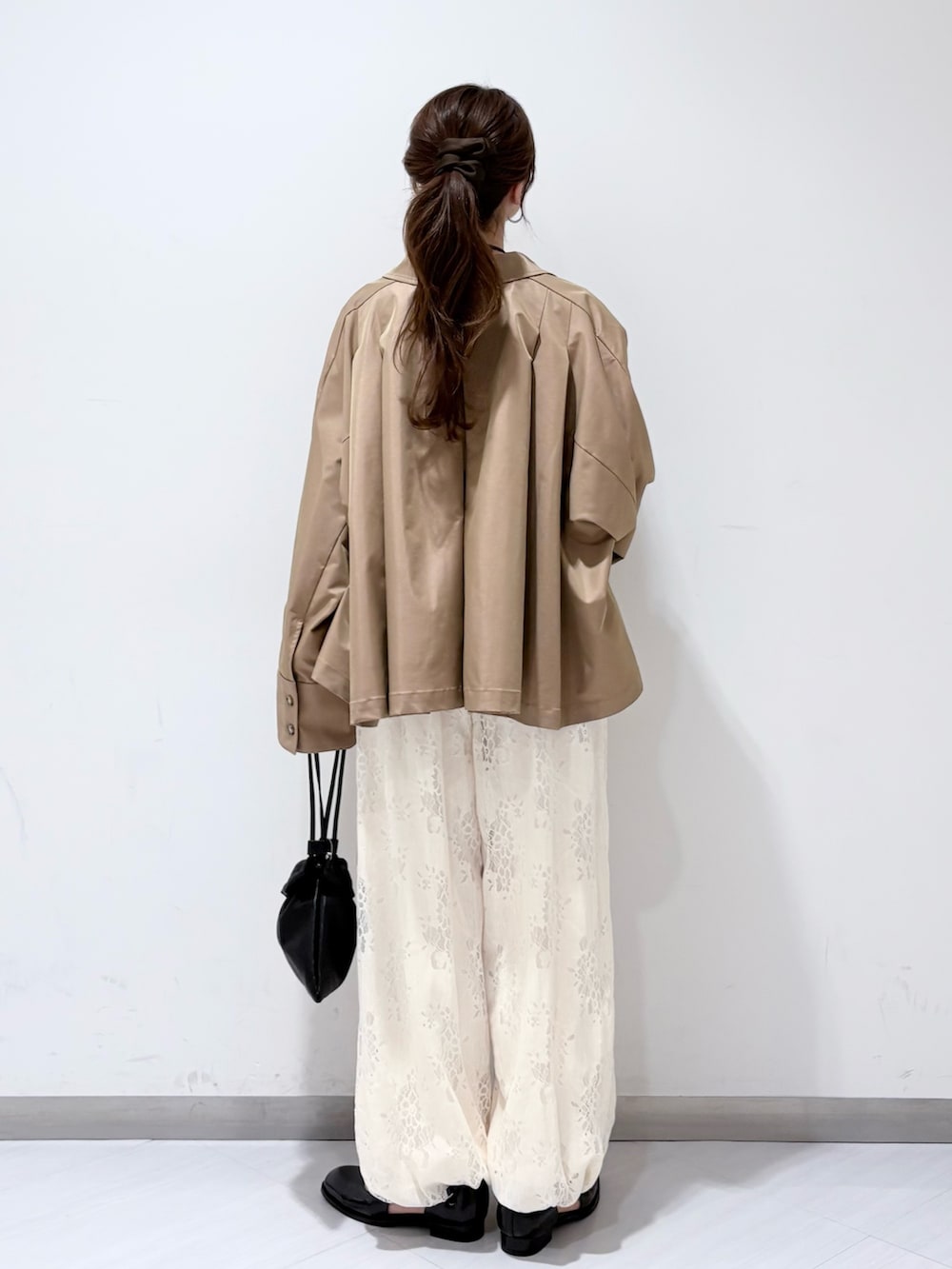 ホワイト系のTシャツ/カットソー、ブラック系のローファー、ブラック系のショルダーバッグを着用したレディースの冬コーディネートの3枚目の写真