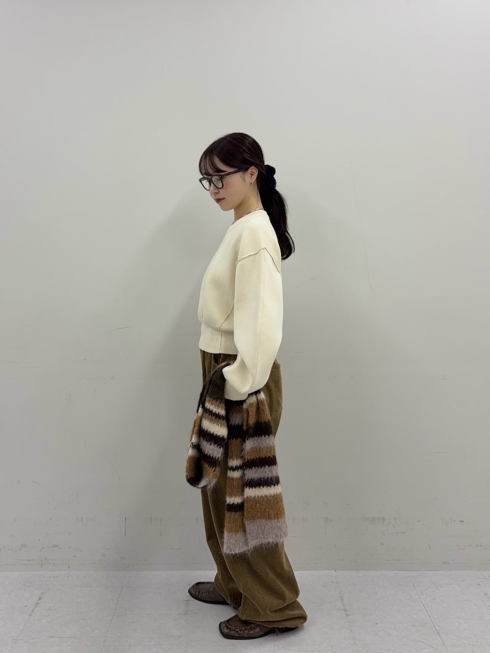 ホワイト系のニット/セーター、ブラウン系のその他パンツ、ブラウン系のローファーを着用したレディースの秋コーディネートの3枚目の写真