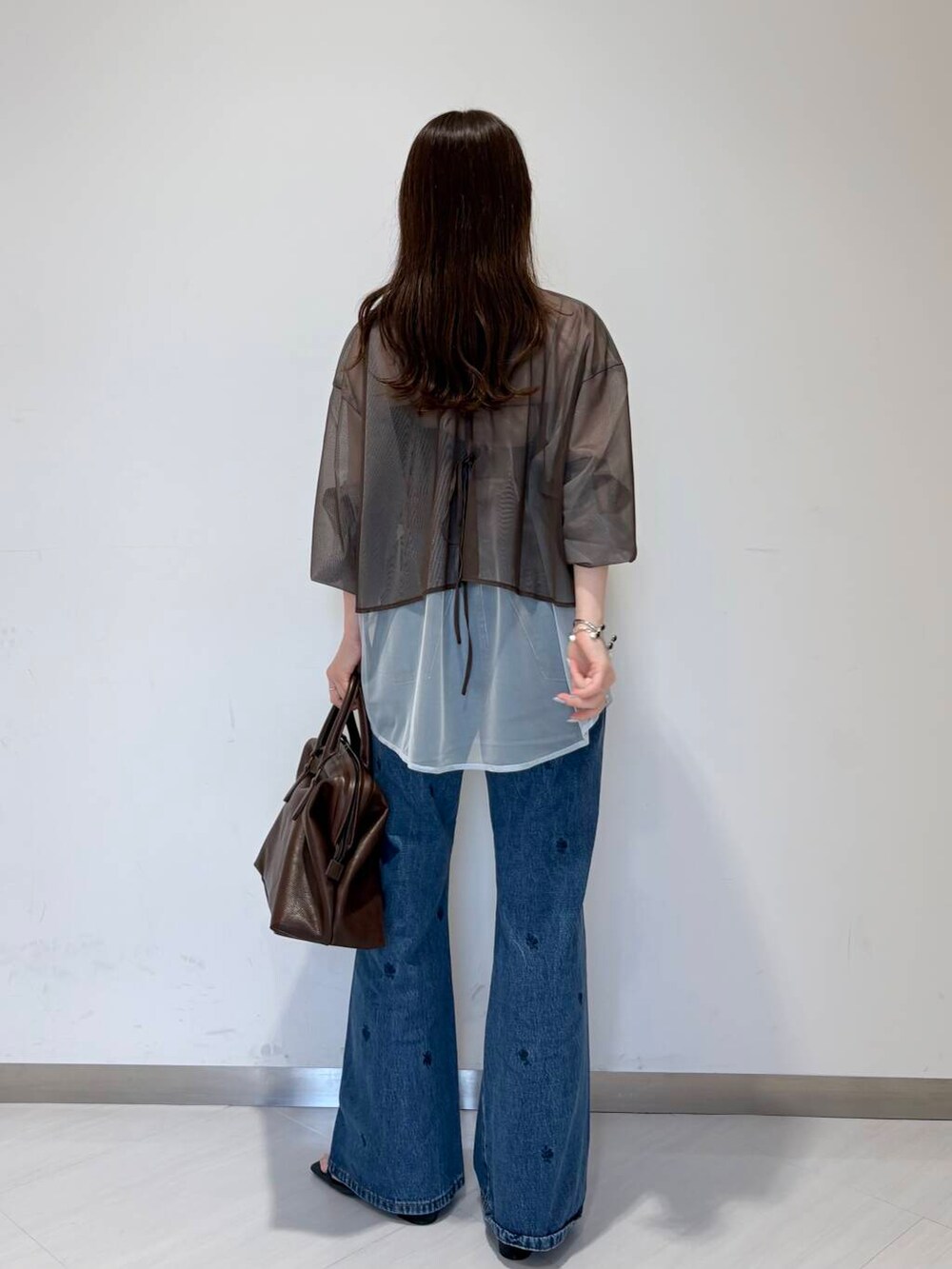 ブルー系のサンダル、ブラック系のキャミソール、ブラウン系のボストンバッグを着用したレディースの夏コーディネートの3枚目の写真