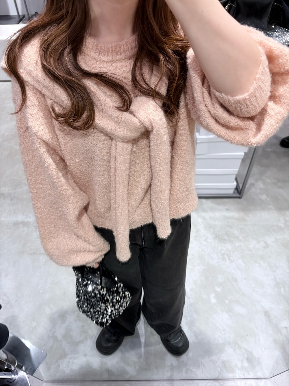 ピンク系のニット/セーター、ブラック系のデニムパンツを着用したレディースの冬コーディネートの4枚目の写真