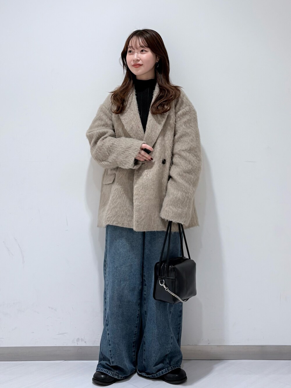ブラウン系のその他アウター、グレー系のニット/セーター、ブルー系のデニムパンツを着用したレディースの冬コーディネートの2枚目の写真