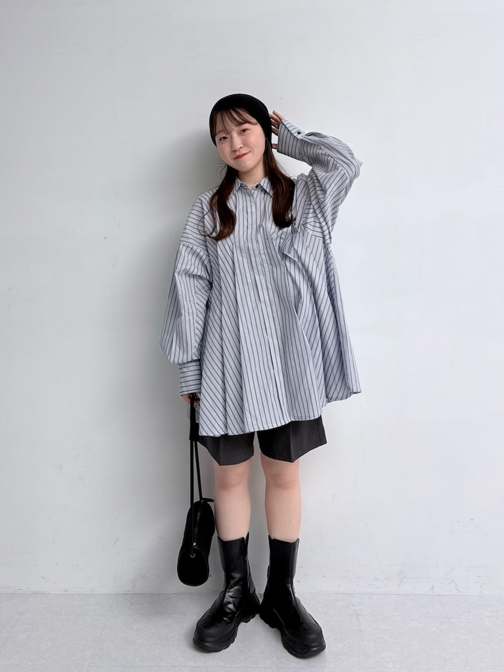 ブルー系のチュニック、グレー系のその他パンツ、ブラック系のショルダーバッグを着用したレディースの夏コーディネートの3枚目の写真