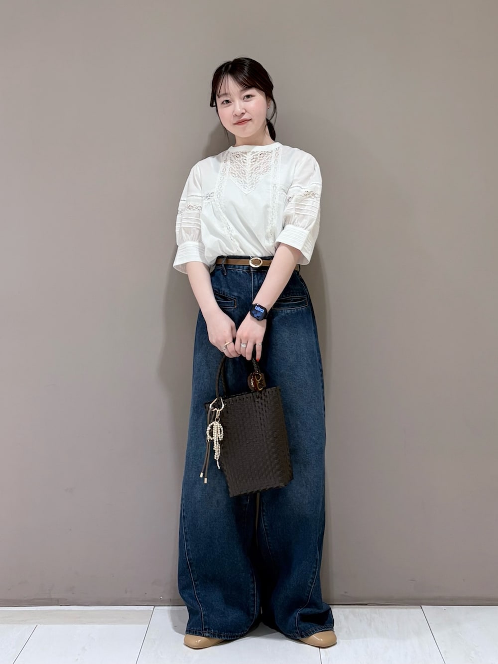 イエロー系のパンプス、ブラウン系のトートバッグ、ブルー系のデニムパンツを着用したレディースの春コーディネートの4枚目の写真