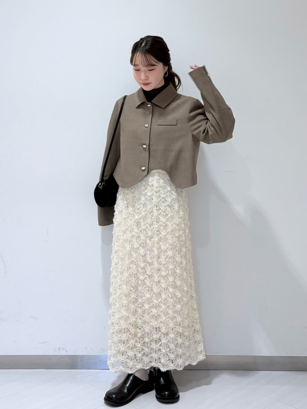 ベージュ系のその他アウター、グリーン系のTシャツ/カットソー、ホワイト系のスカートを着用したレディースの秋コーディネートの2枚目の写真