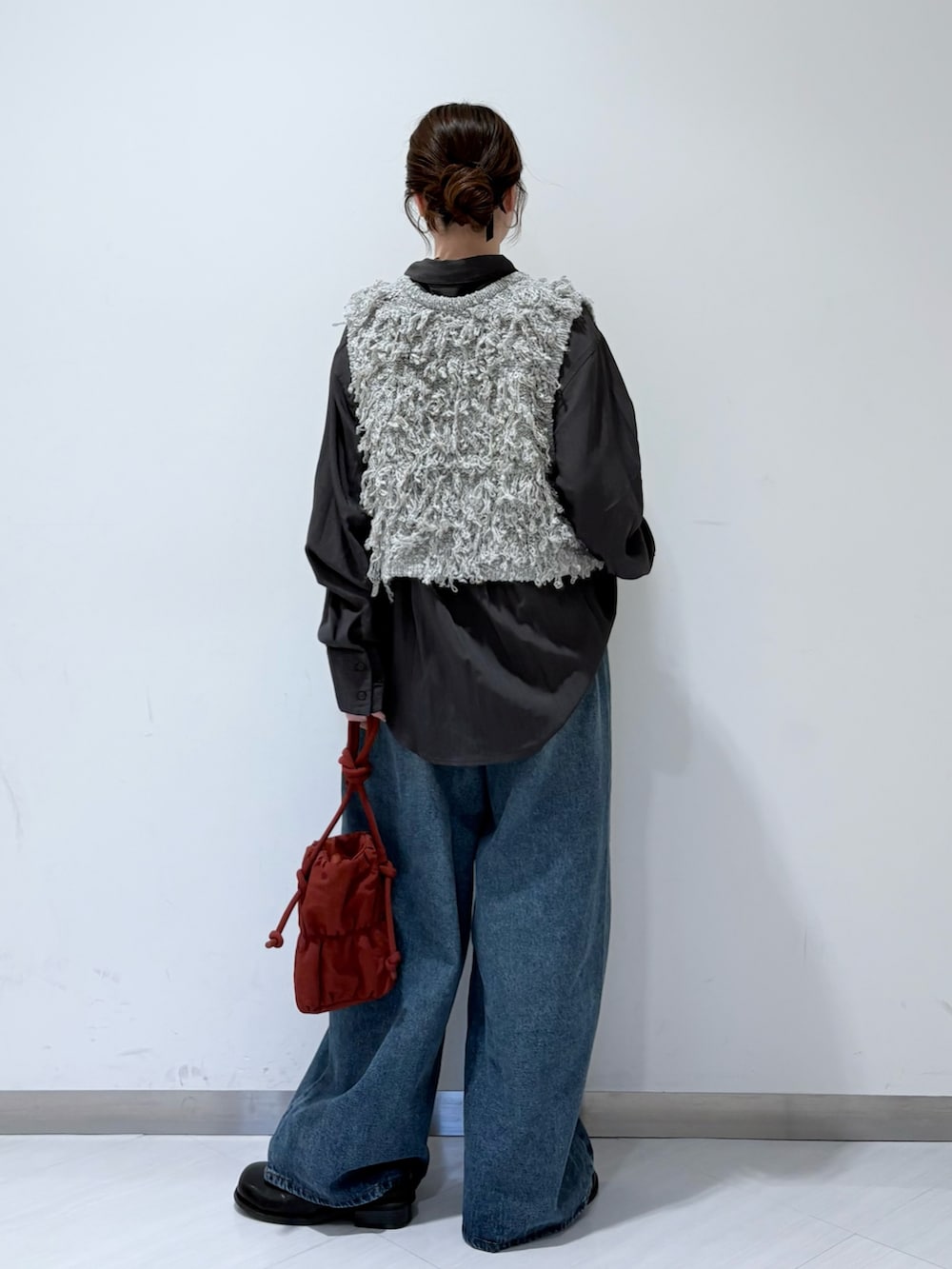 グレー系のベスト、グレー系のシャツ/ブラウス、ブルー系のデニムパンツを着用したレディースの秋コーディネートの3枚目の写真