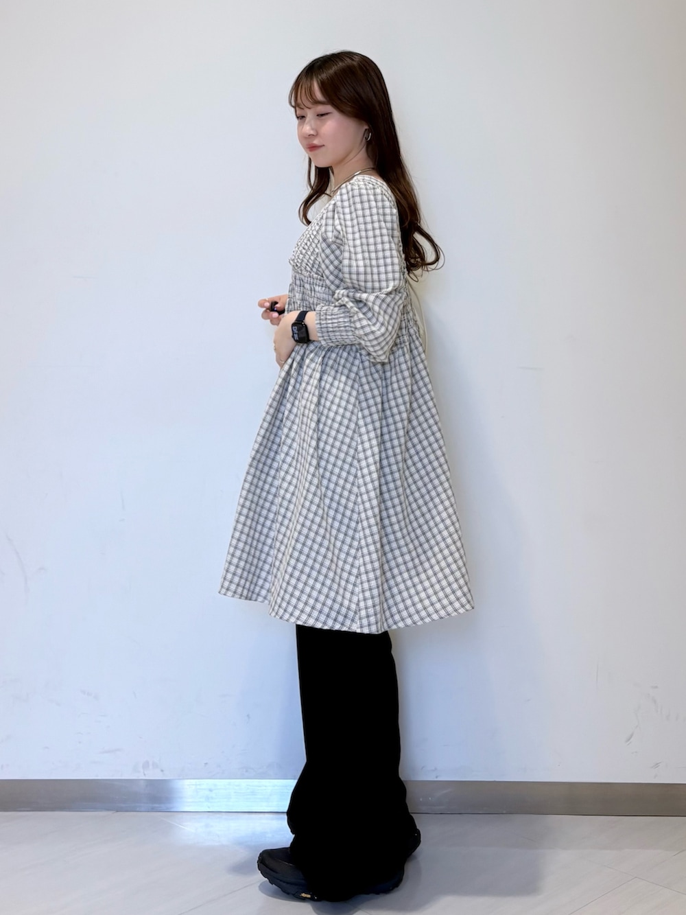 ブラック系のその他パンツ、ベージュ系のワンピース、ホワイト系のショルダーバッグを着用したレディースの春コーディネートの3枚目の写真