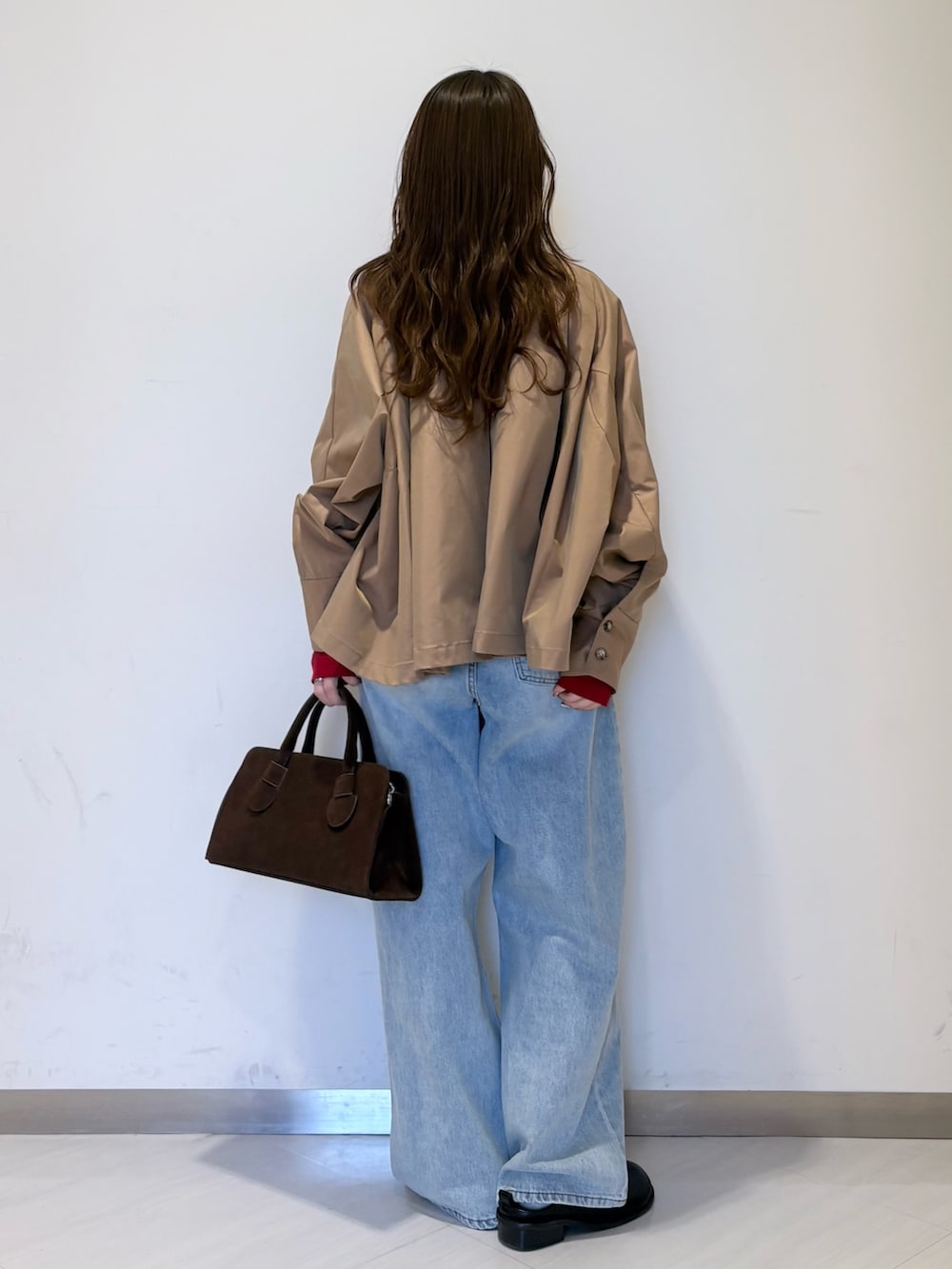 ブラック系のその他シューズ、ベージュ系のステンカラーコート、レッド系のニット/セーターを着用したレディースの春コーディネートの3枚目の写真