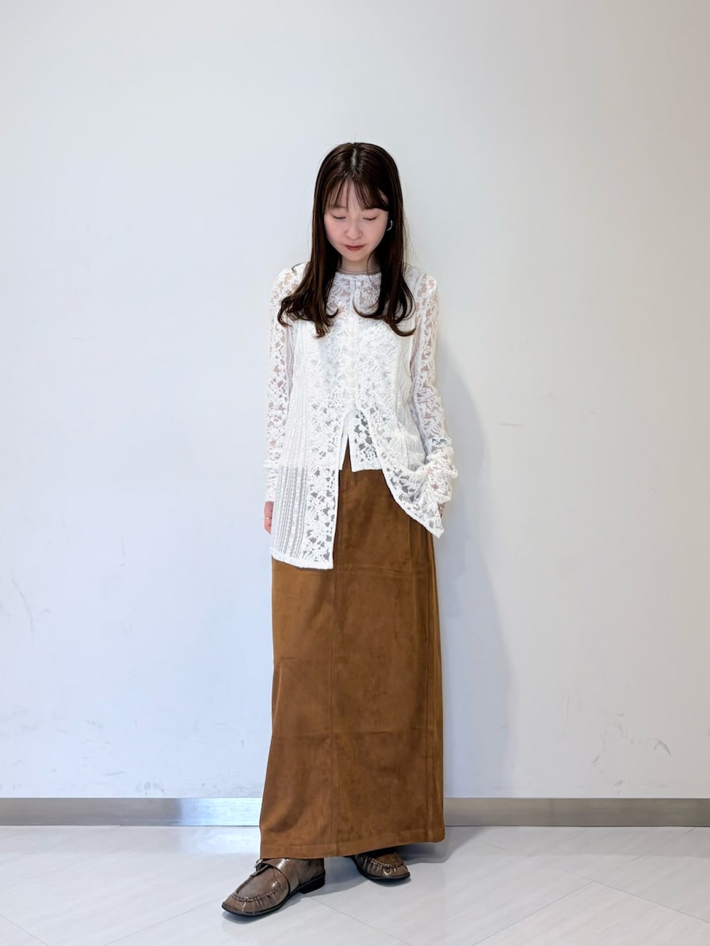 ホワイト系のカーディガン/ボレロ、ブラウン系のスカート、ブラウン系のローファーを着用したレディースの夏コーディネートの2枚目の写真