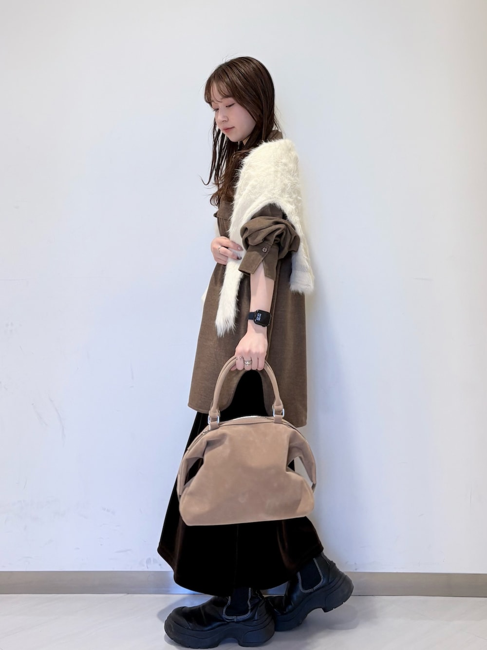 ブラウン系のシャツ/ブラウス、ホワイト系のニット/セーター、ブラウン系のスカートを着用したレディースの冬コーディネートの3枚目の写真