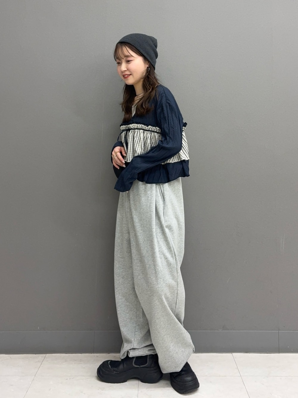 グレー系のその他パンツ、ブラック系のショルダーバッグ、ブルー系のシャツ/ブラウスを着用したレディースの冬コーディネートの2枚目の写真