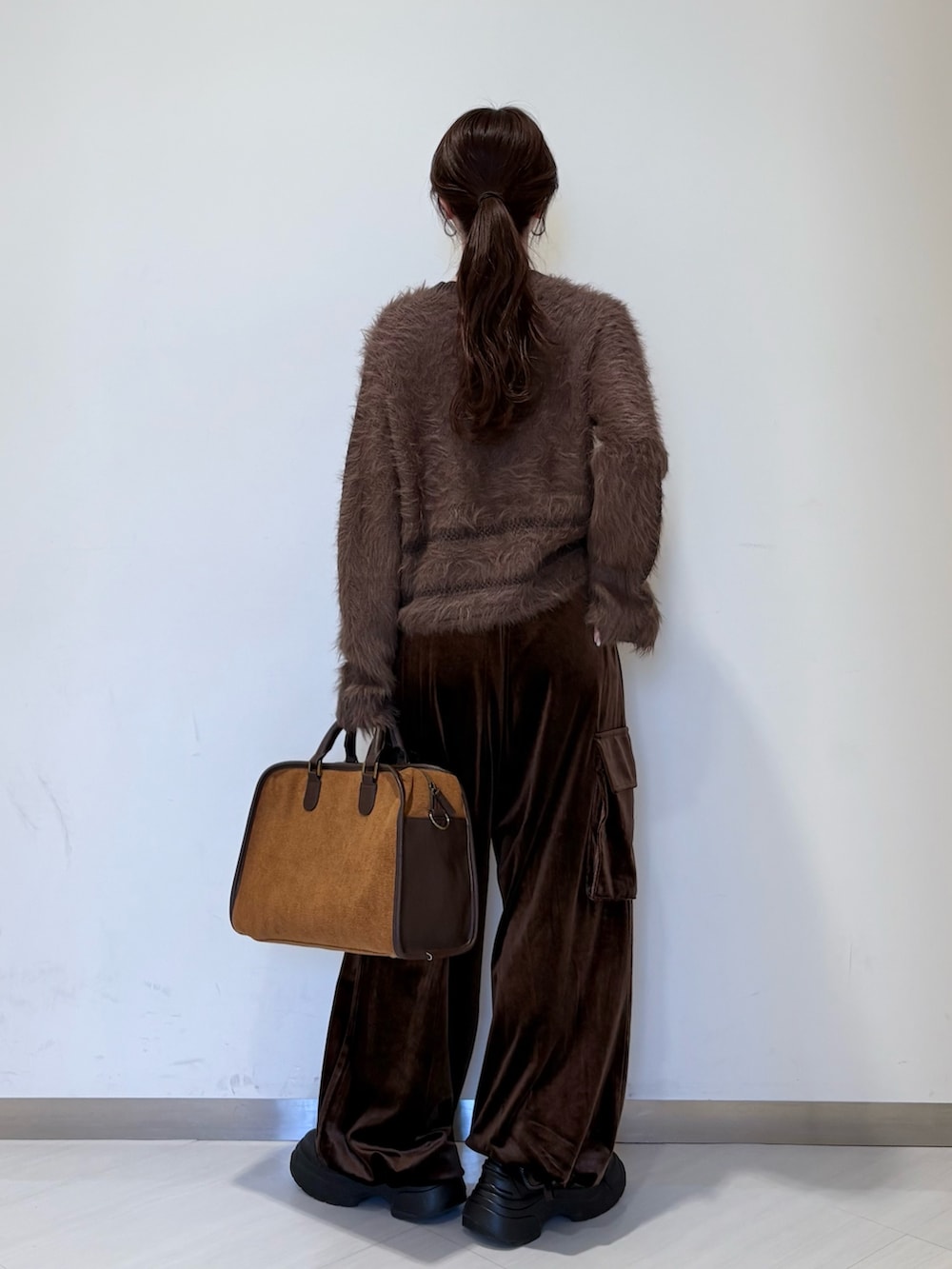 ブラウン系のその他パンツ、ブラウン系のニット/セーター、イエロー系のボストンバッグを着用したレディースの秋コーディネートの3枚目の写真