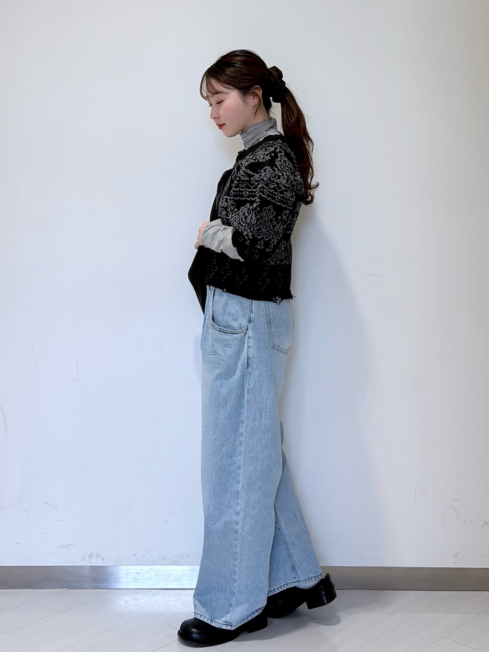 ブルー系のニット/セーター、ブラック系のその他シューズ、グレー系のTシャツ/カットソーを着用したレディースの冬コーディネートの2枚目の写真