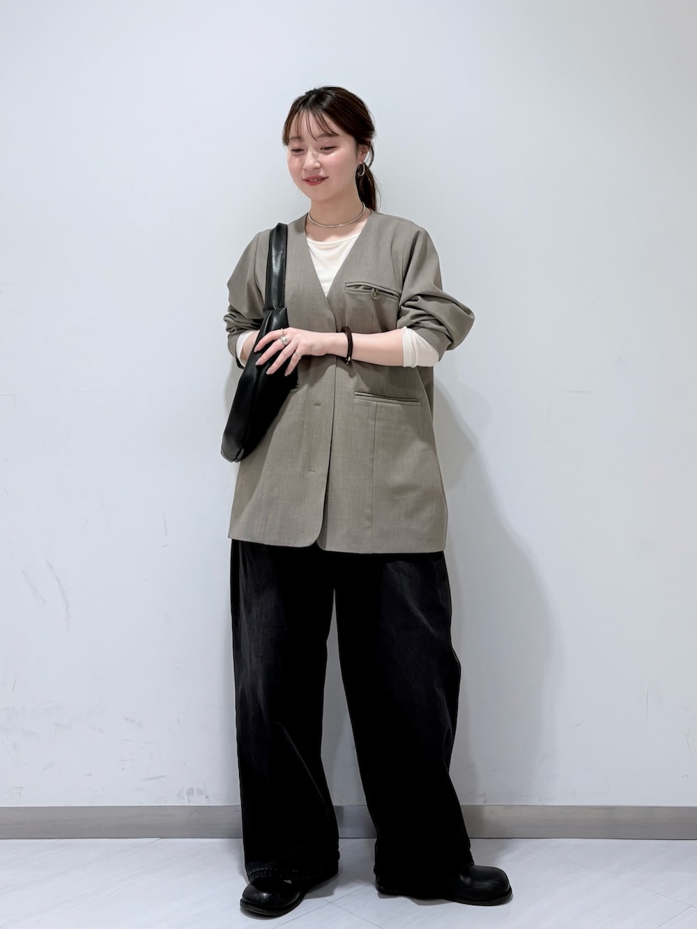 ブラック系のその他シューズ、グレー系のノーカラージャケット、ホワイト系のTシャツ/カットソーを着用したレディースの冬コーディネートの2枚目の写真