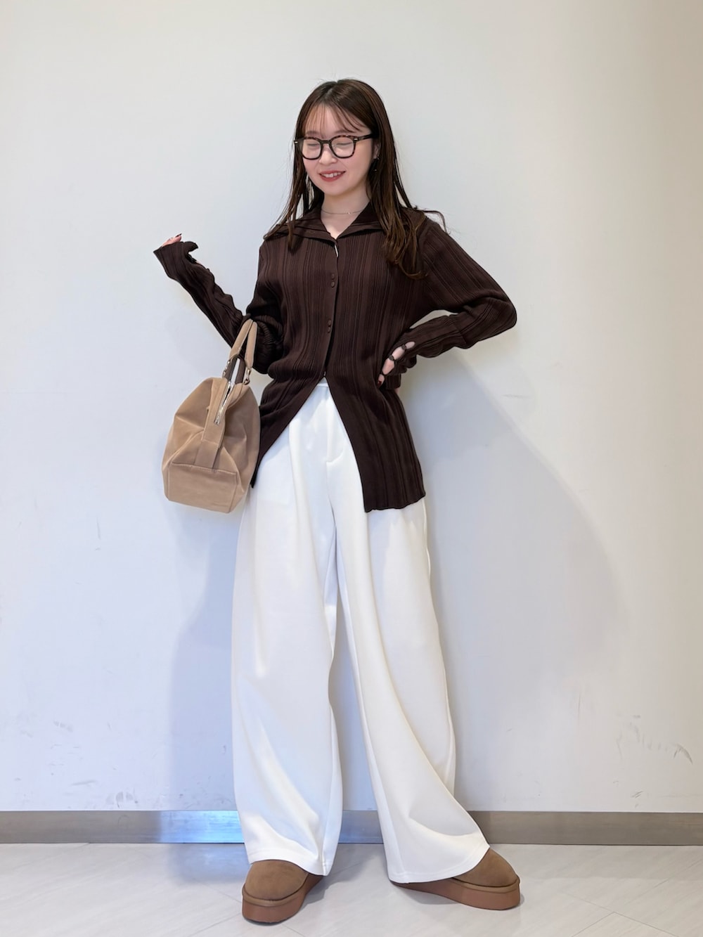 ブラウン系のニット/セーター、ホワイト系のその他パンツ、ベージュ系のボストンバッグを着用したレディースの冬コーディネートの3枚目の写真