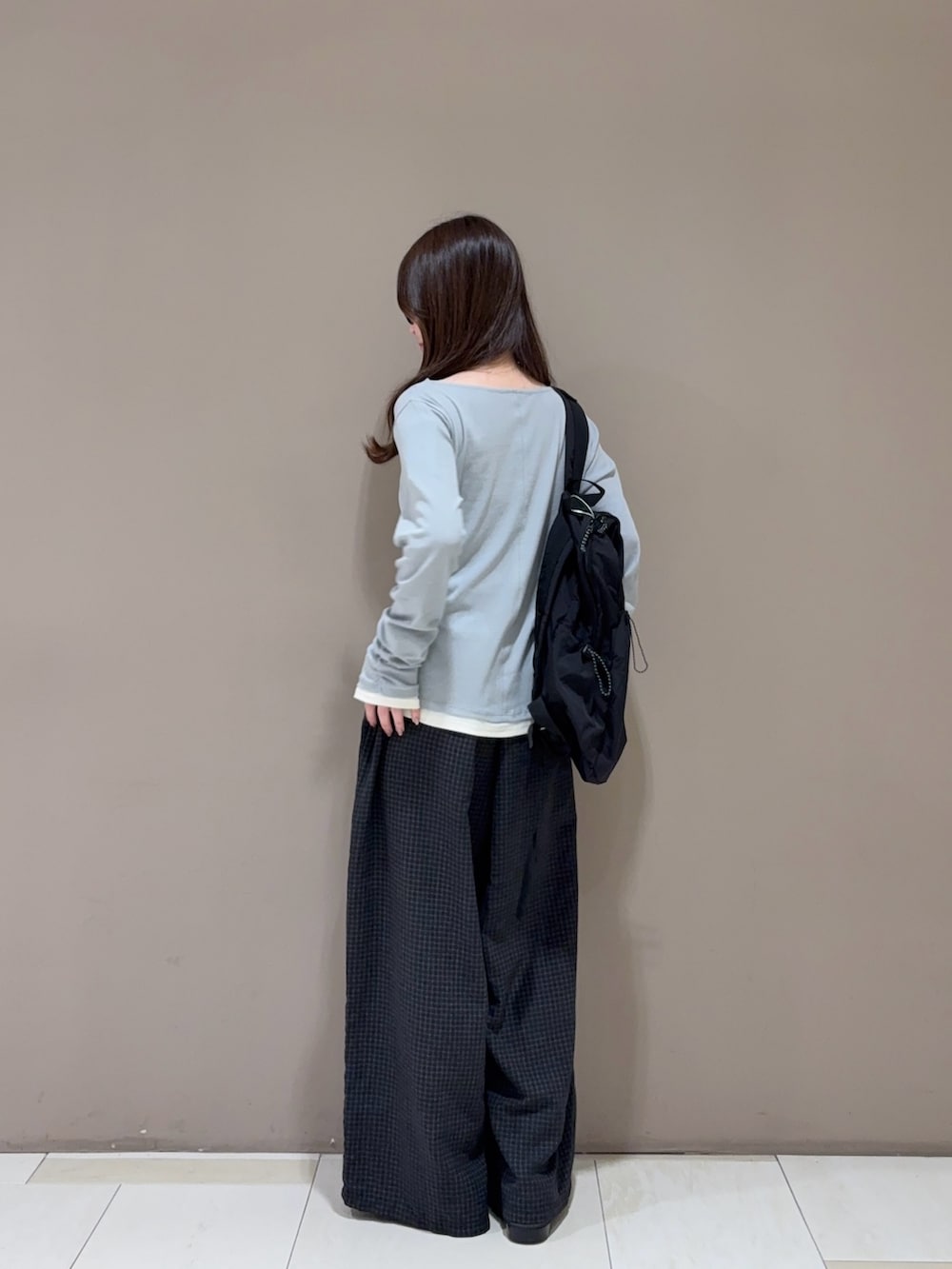 ブラウン系のローファー、グレー系のその他パンツ、ブラック系のバックパック/リュックを着用したレディースの秋コーディネートの3枚目の写真