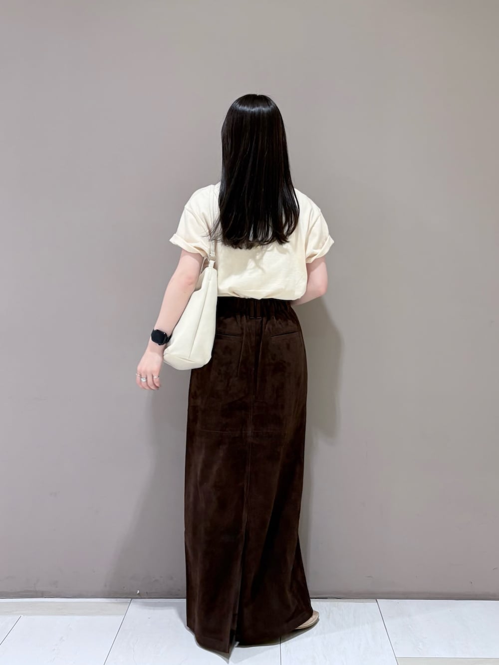 ブラウン系のスカート、ホワイト系のショルダーバッグ、ホワイト系のTシャツ/カットソーを着用したレディースの夏コーディネートの3枚目の写真