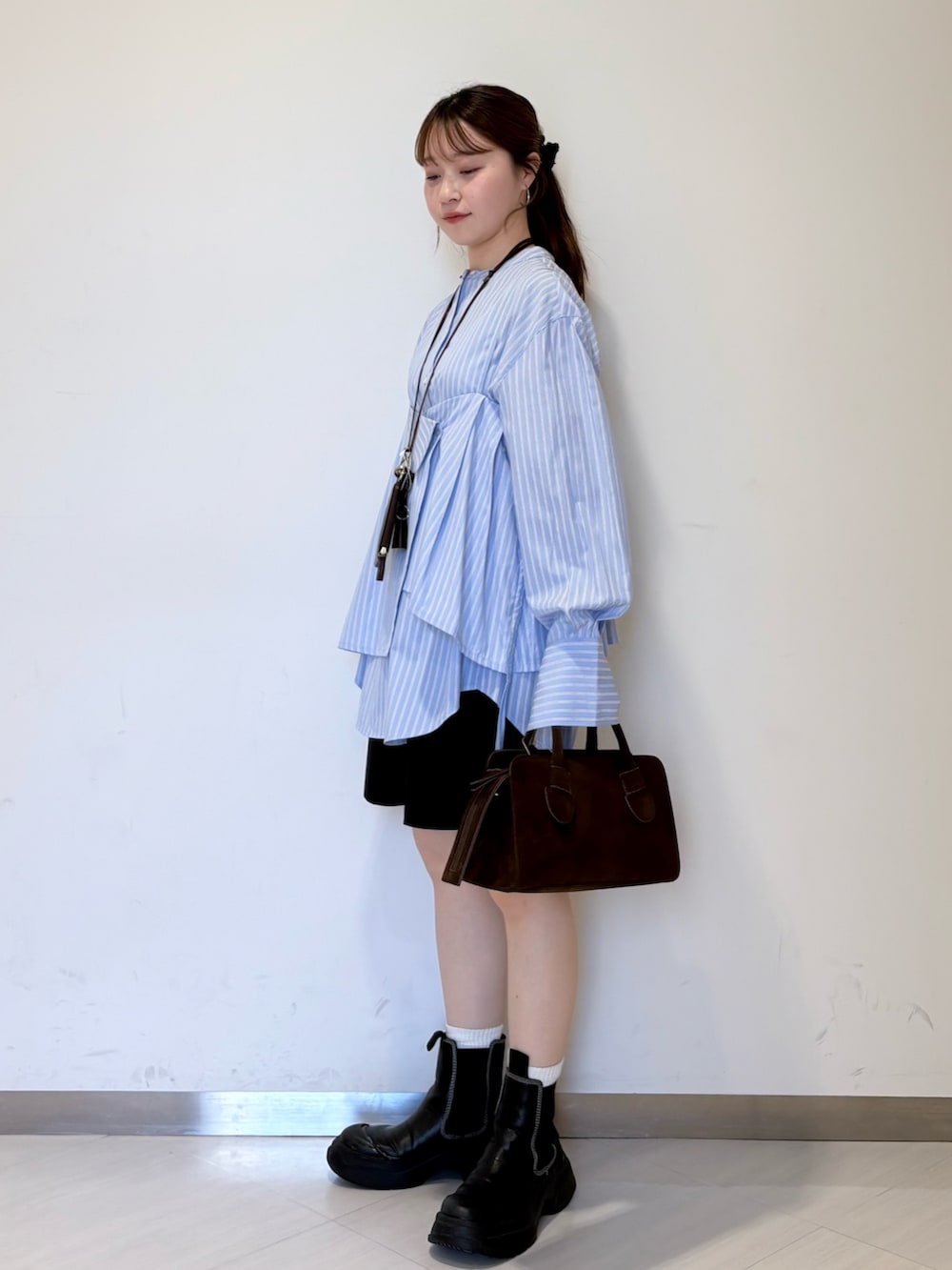 ブルー系のシャツ/ブラウス、ブラック系のその他パンツ、ブラウン系のショルダーバッグを着用したレディースの春コーディネートの3枚目の写真