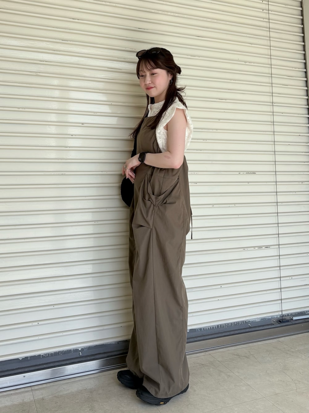 ブラウン系のその他パンツ、ブラック系のショルダーバッグ、ホワイト系のシャツ/ブラウスを着用したレディースの夏コーディネートの2枚目の写真