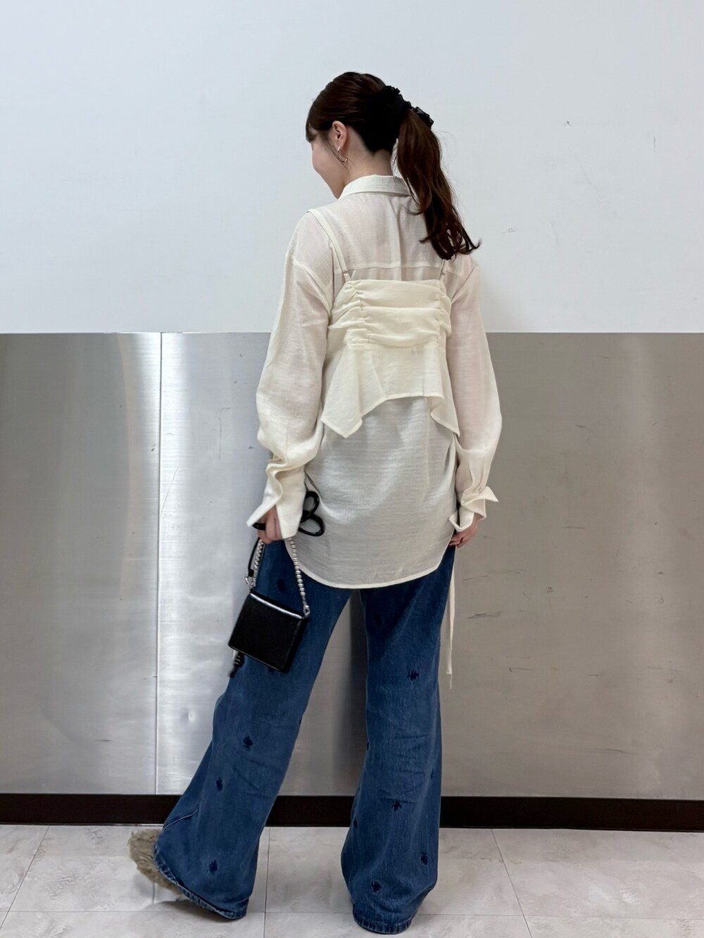 ブラウン系のその他アウター、ホワイト系のシャツ/ブラウス、ブルー系のデニムパンツを着用したレディースの秋コーディネートの5枚目の写真