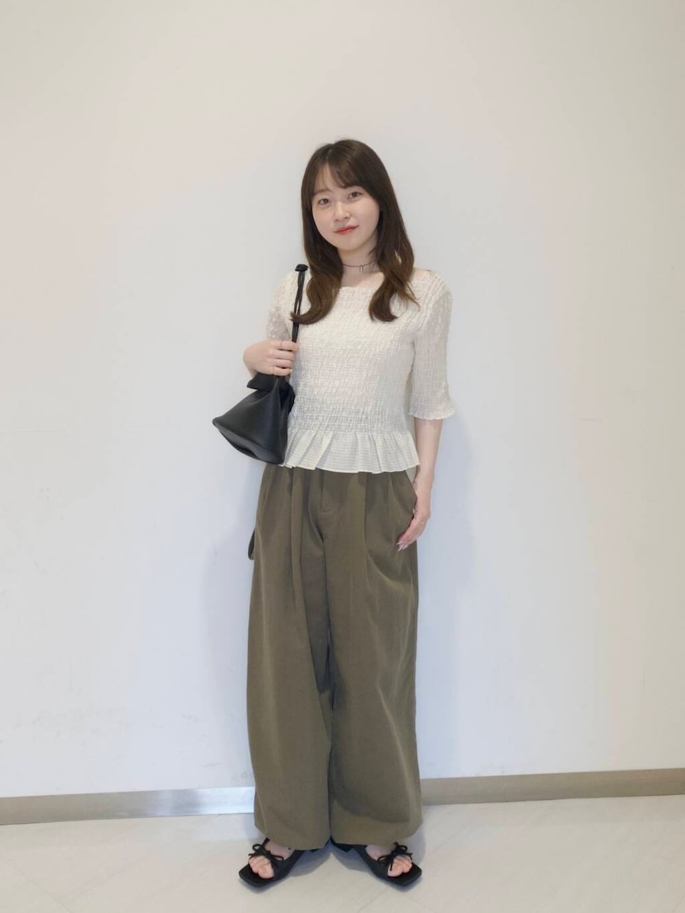 グリーン系のその他パンツ、ブラック系のショルダーバッグ、ブラック系のサンダルを着用したレディースの春コーディネートの2枚目の写真