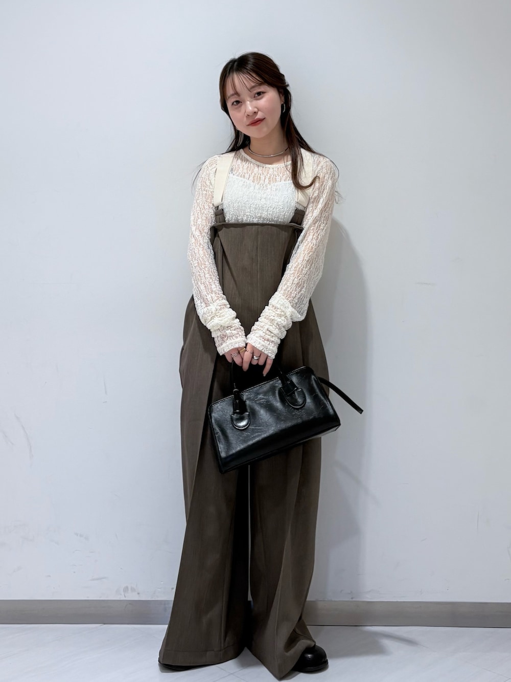 ホワイト系のTシャツ/カットソー、ブラウン系のその他パンツ、ブラウン系のボストンバッグを着用したレディースの冬コーディネートの2枚目の写真