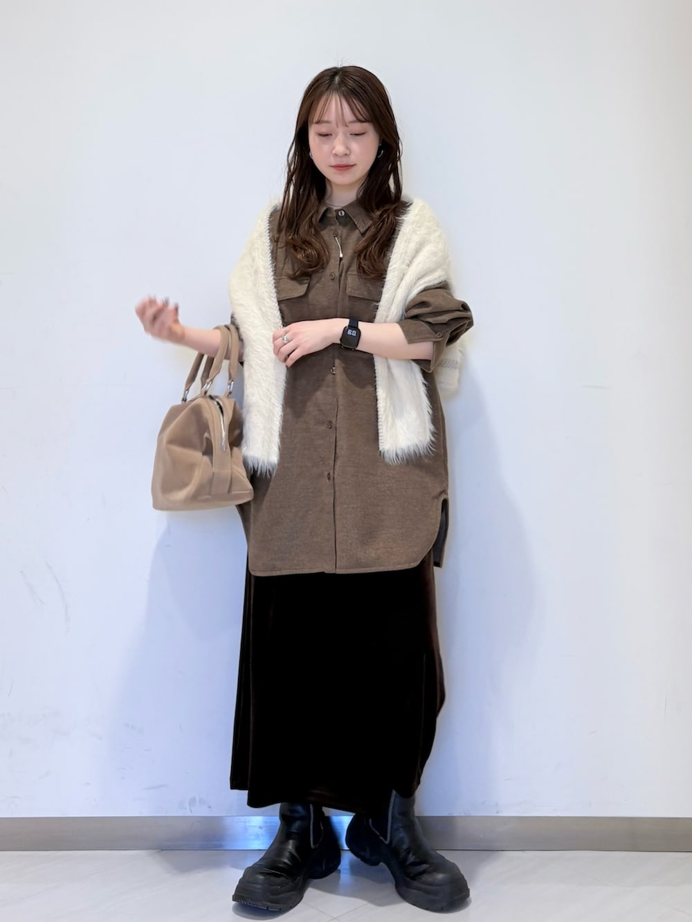 ブラウン系のシャツ/ブラウス、ホワイト系のニット/セーター、ブラウン系のスカートを着用したレディースの冬コーディネートの4枚目の写真