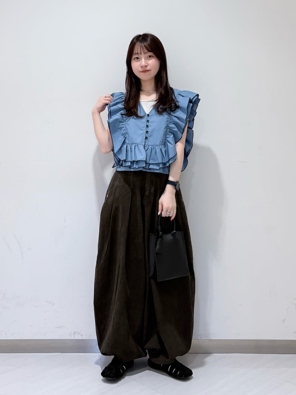 ブルー系のシャツ/ブラウス、ブラック系のサンダル、ブラウン系のその他パンツを着用したレディースの春コーディネートの4枚目の写真